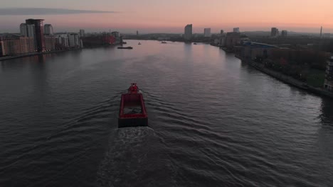 drone follow shot of barge boat on the thames river sunset