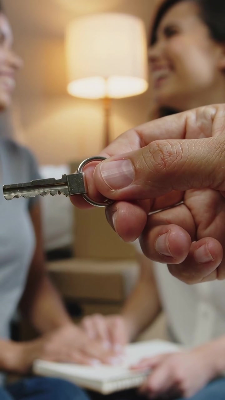 Video verticale: Offerta della chiave di casa, donne che si tengono per mano su un quaderno a spirale sorridendo, segnalando un trasloco