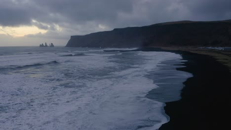 scenery of foamy waves crashing the víkurfjara beach near vestmannaeyjar in iceland