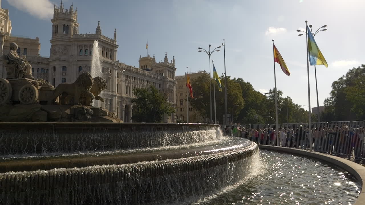 Fontana di Cibele e Palazzo di Cibele a Madrid con persone e bandiere