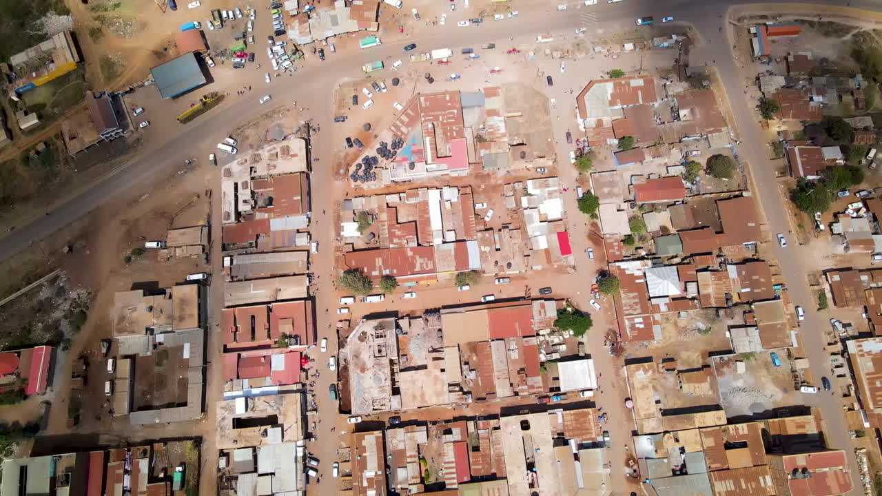 Vista aerea su piccole strade trafficate verso la strada principale che attraversa una città mozzafiato nel Kenya rurale