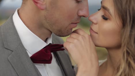 Lovely-young-newlyweds-bride-and-groom-embracing,-hugging-on-mountain-slope,-wedding-couple-in-love