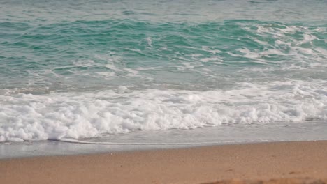 soft ocean waves hitting the sandy beach on a sunny day