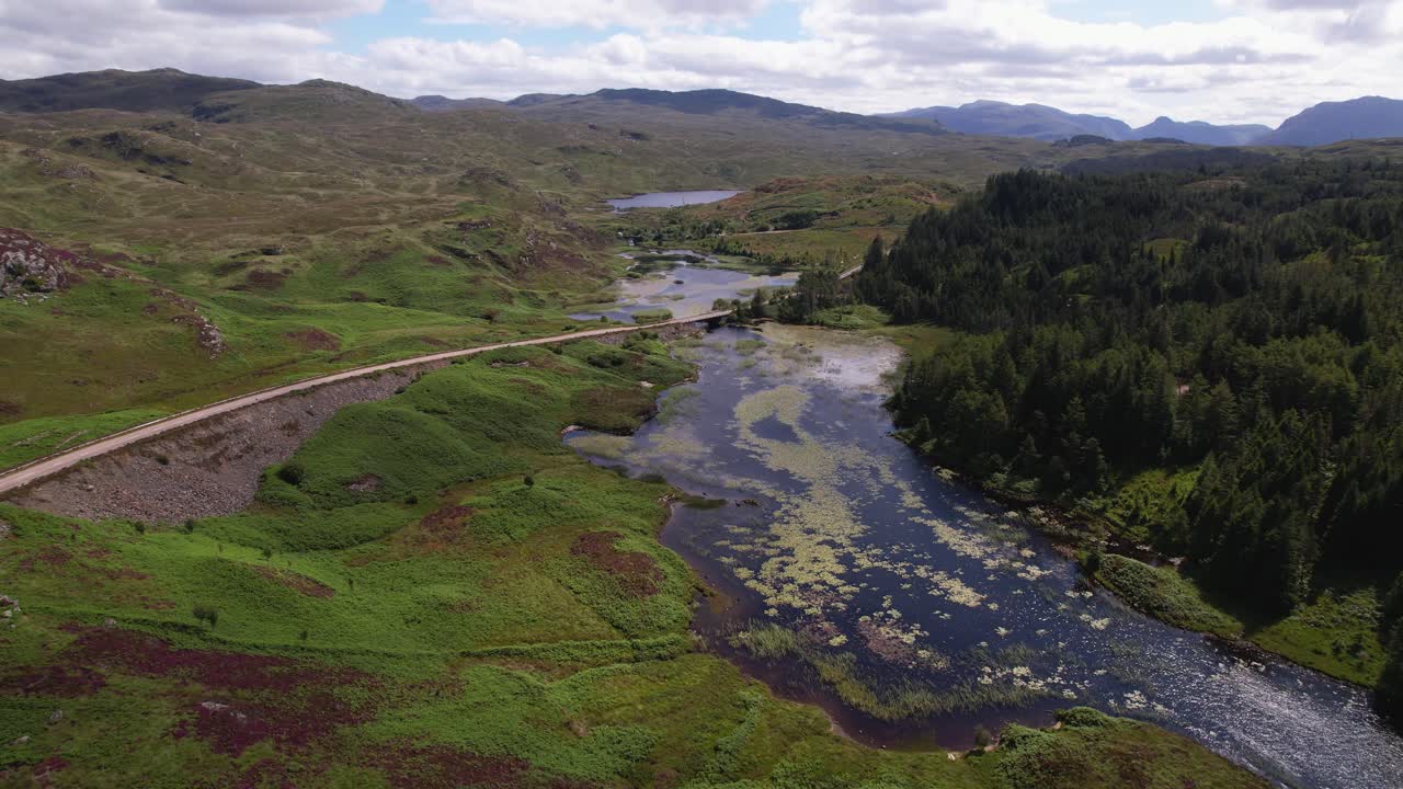 una panorámica aérea de los exuberantes valles verdes de escocia, las colinas, los ríos y la naturaleza serena