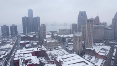 Downtown-Detroit-covered-in-snow-during-light-snowstorm,-aerial-view
