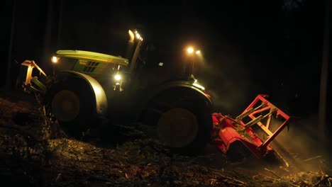 el triturador forestal procesa restos de árboles después de la infestación de escarabajos de corteza en terrenos escarpados por la noche