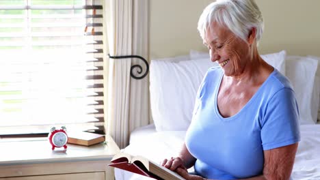 Mujer-Mayor-Leyendo-Un-Libro-En-El-Dormitorio