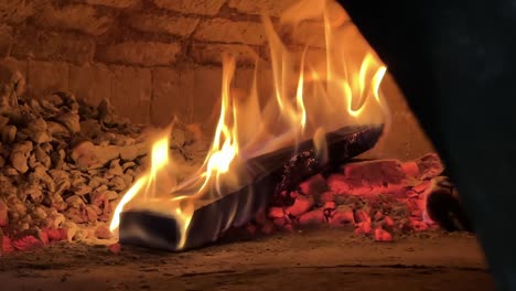 close up of log of wood burning in slow motion in the typical oven for pizza in naples