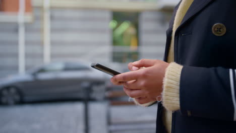 manos femeninas con teléfonos inteligentes caminando calle de la ciudad desenfocada sola de cerca.
