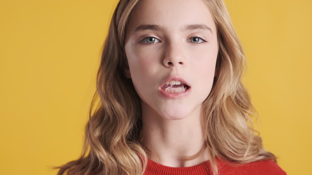 Teenage Caucasian girl chewing gum and blowing bubble.