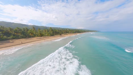 fpv dynamic flight over beautiful ocean water,sandy beach along coastline with palm trees - playa coson beach,dominican republic