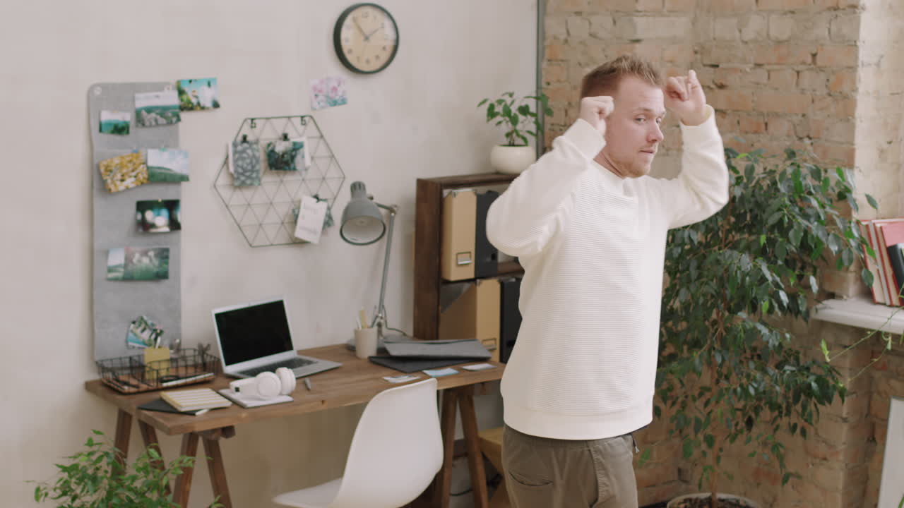 Attractive Man Dancing to Music in Apartment