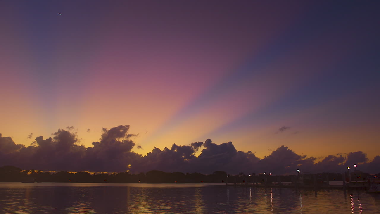 rayos de sol antes del amanecer saliendo de detrás de las nubes en el sur de florida, u