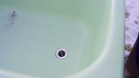 a man is inserting a drain stopper into the diy hot tub - close up