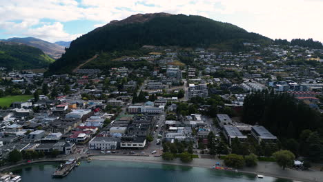 Aerial-dolly-out-revealing-downtown-of-Queenstown-in-moody-cloudy-weather,-New-Zealand