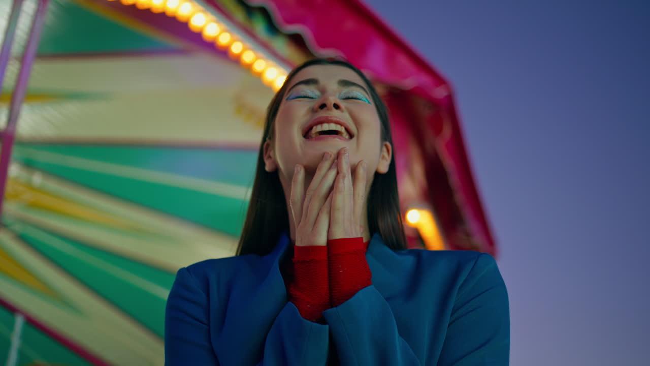 Closeup excited girl enjoying holiday night at amusement park. Joyful female