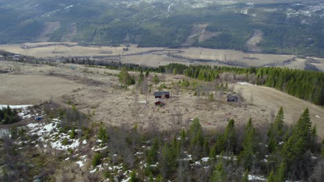 Aerial-view-approaching-a-distant-hut,-in-the-remote-wilderness-of-central-Norway---tilt,-drone-shot