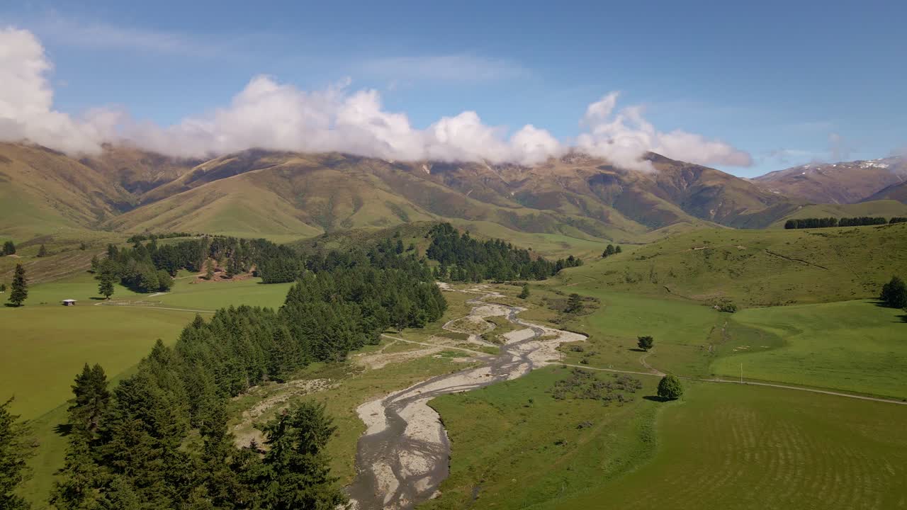 Fiume tortuoso che scende dalle montagne e scorre attraverso un ampio letto fluviale.