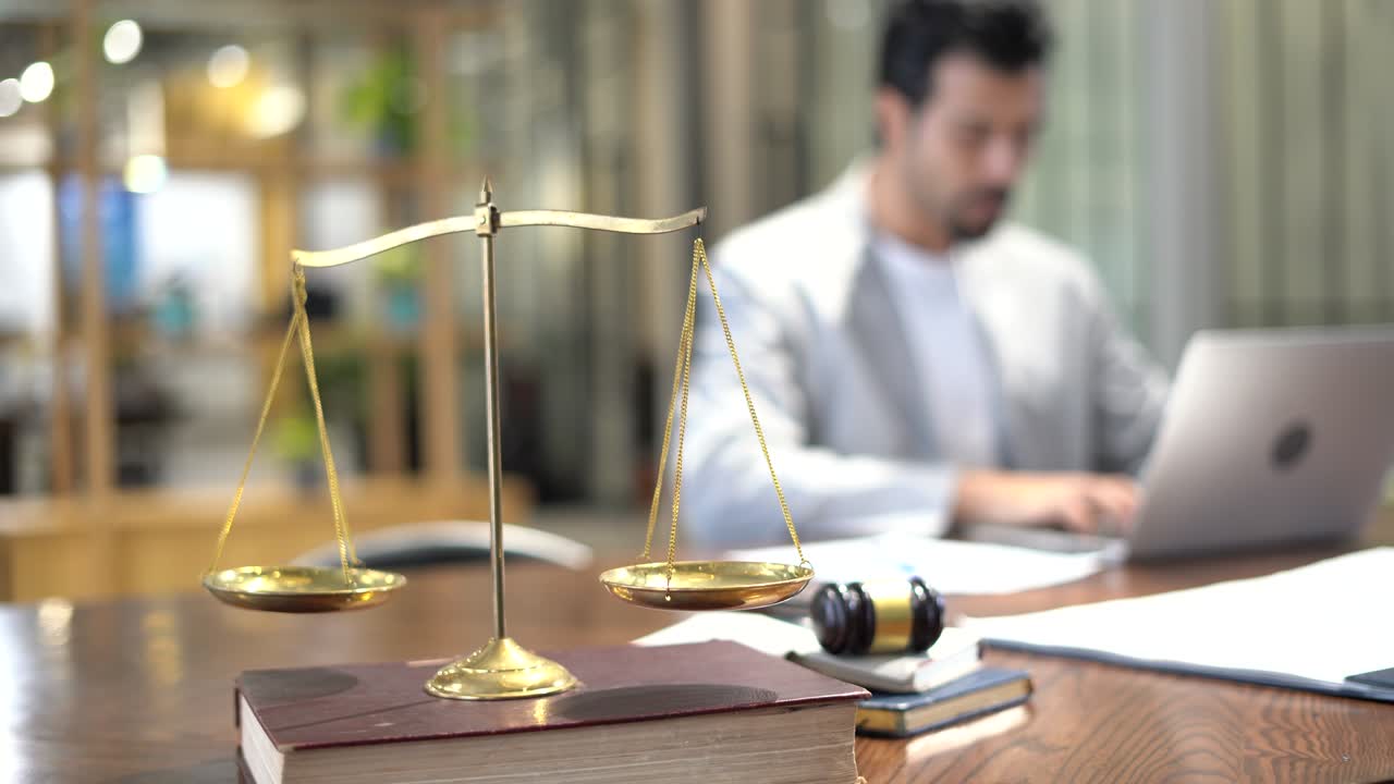 advogado sério trabalhando com computador portátil e tomar nota tomar nota de processo no escritório com martelo de madeira com escala dourada na mesa. homem de negócios estresse de fazer um caso.