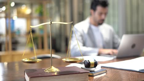 abogado serio trabajando con computadora portátil y tomar nota tomar nota de la demanda en la oficina con martillo de madera con escala de oro en la mesa. hombre de negocios estrés de hacer un caso.
