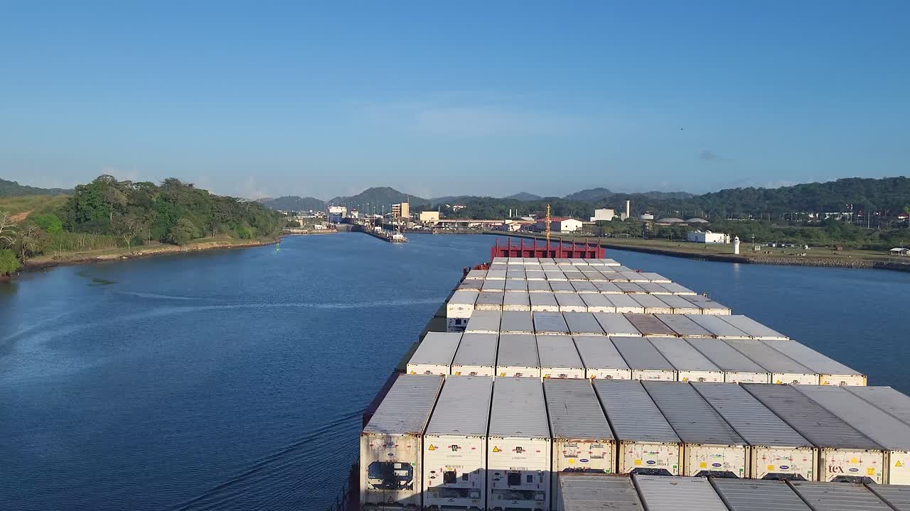 Massive container ship transiting the Panama Canal towards the Atlantic Ocean gates under a clear blue sky