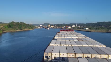 massive container ship transiting the panama canal towards the atlantic ocean gates under a clear blue sky