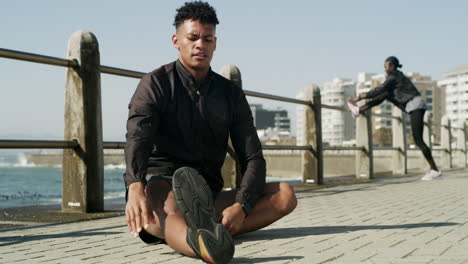 a man stretching while out on the promenade