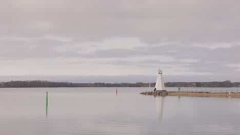 Vista-Pintoresca-Del-Reflejo-Del-Faro-De-Vadstena-En-El-Lago-Vattern-En-Vadstena,-Suecia