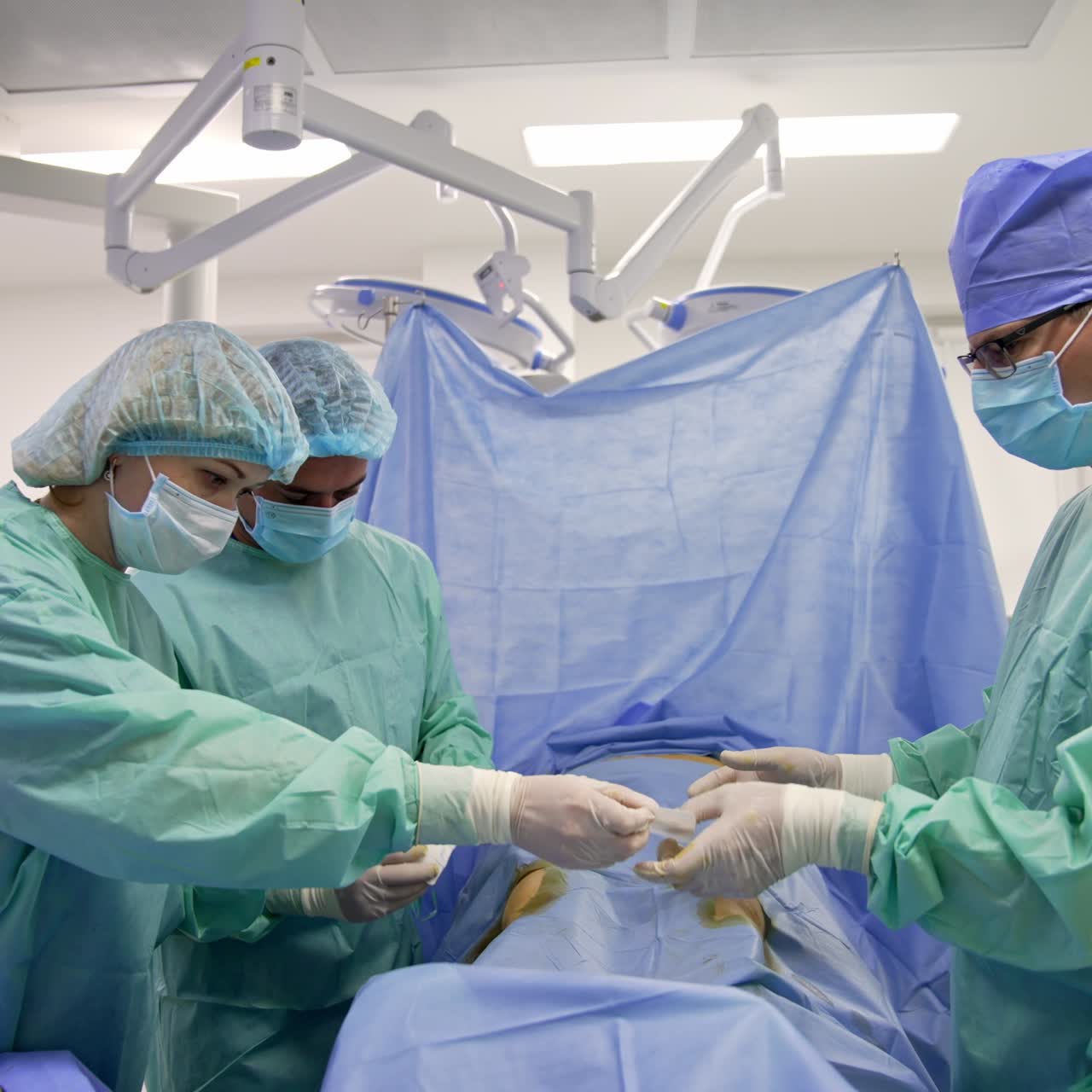 Surgeon's team doing procedure in surgery room. Doctors perform operation on the patient's knees