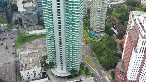 Slow-tilt-up-shot-reveals-downtown-cityscape-at-central-kuala-lumpur-featuring-iconic-petronas-twin-towers-surrounded-by-urban-high-rise-architectures-and-commercial-office-buildings