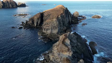 drone video over small rocky islands panning down at the end