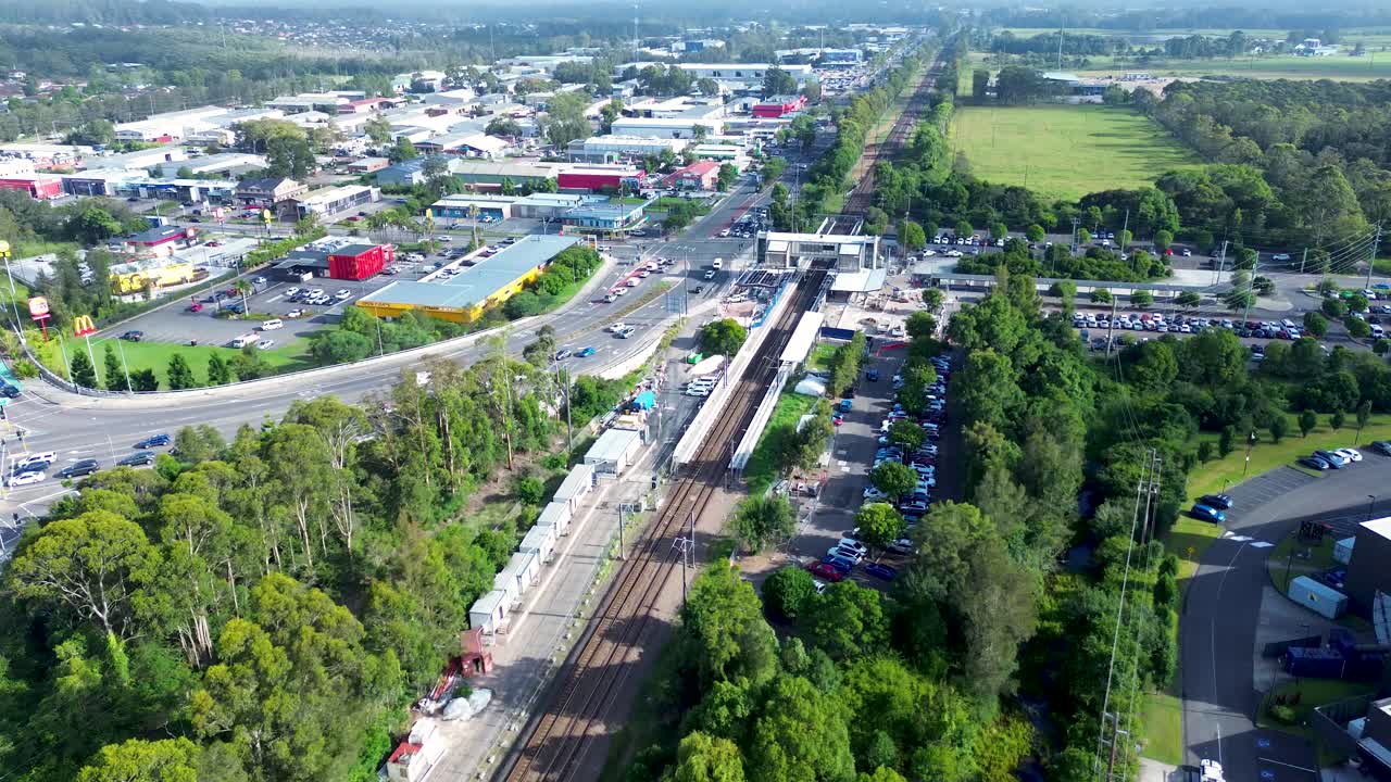 Drone aerial landscape of car vehicles traffic on highway street with Tuggerah train station railway tracks Central Coast Wyong suburbs Australia transport tourism travel