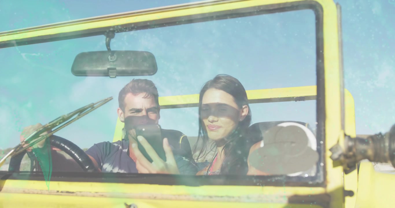 Driver lifting smartphone, couple leaning in yellow jeep, sharing travel content with light leaks
