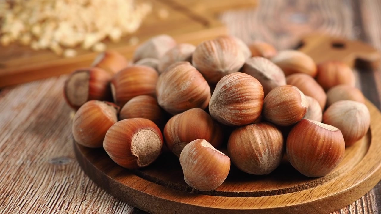 Pile of Fresh Whole Hazelnuts on a Wooden Cutting Board
