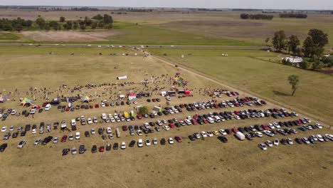 el vuelo circular de un dron sobre el estacionamiento de un evento de aeromodelismo en buenos aires muestra las masas de autos estacionados