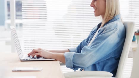 mujer de negocios trabajando en una computadora portátil en su escritorio