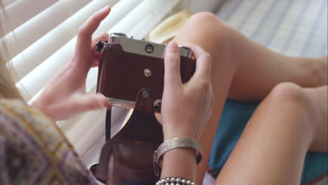 girl using vintage camera at home