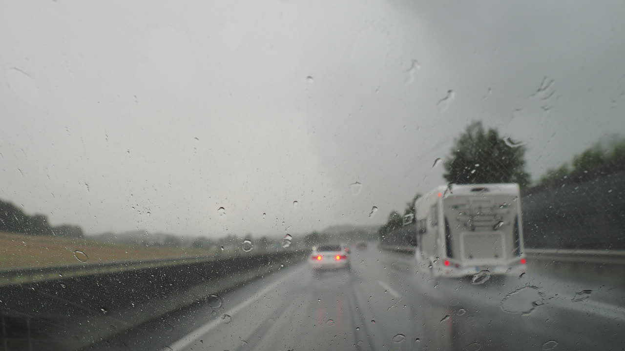 자동차 창문에 방울이 떨어지는 폭풍우 운전