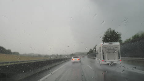 conducción tormentosa con gotas de lluvia en la ventana del coche