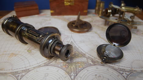 vintage compass, telescope, sun dial and a nautical sextant lying on ancient world map