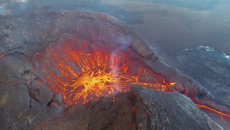 amazing night drone aerial high view of active volcano crater fagradalsfjall volcano with lava boulders falling in in iceland