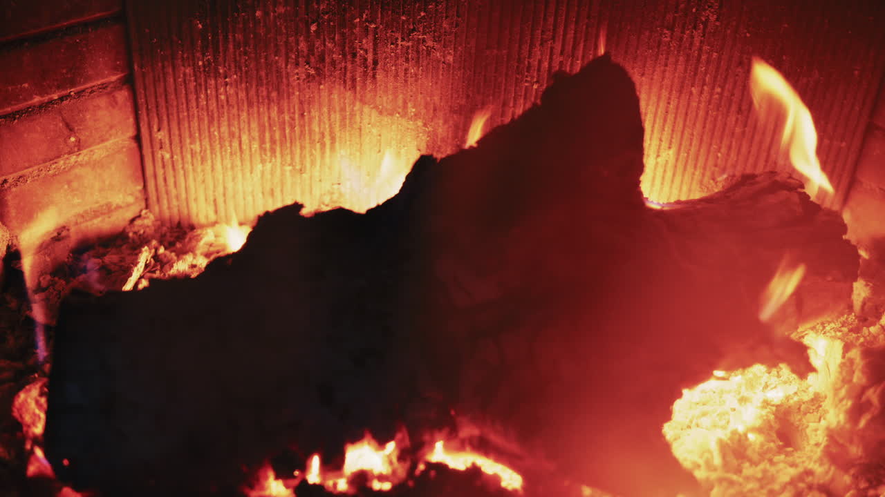 Brennholz, das in einem Kamin mit glühenden Kohlen und warmen Flammen brennt