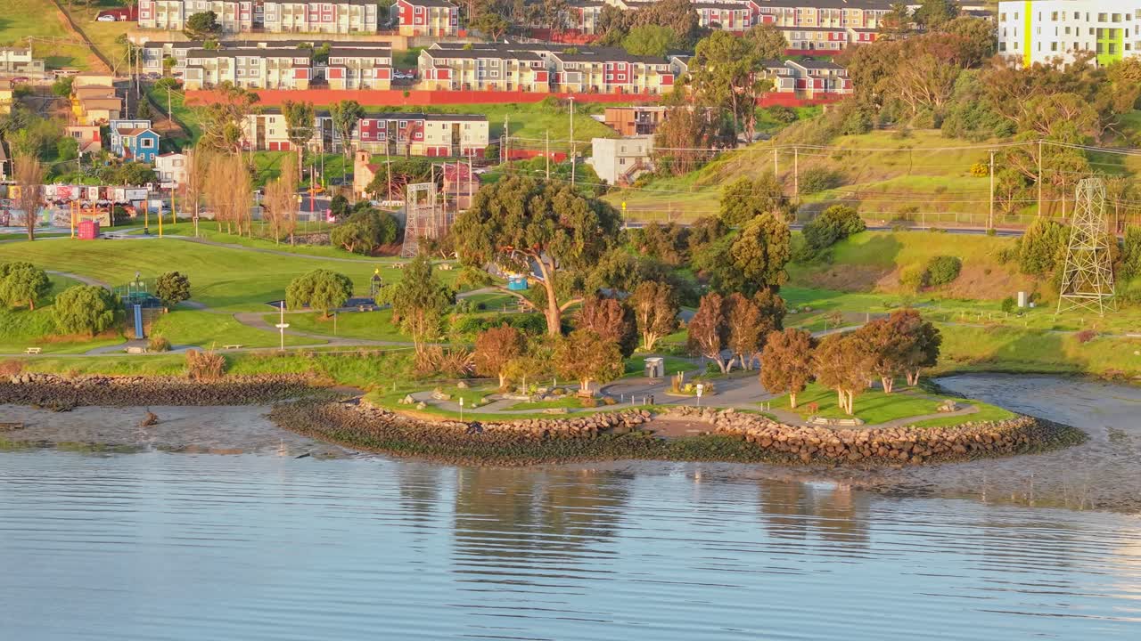 A slow left to right panning shot of Heron's Head Park and the surrounding neighborhood of the area.