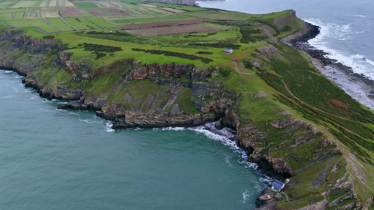 Descending into rocky cove surrounded by steep rugged cliffs on Worms head Wales