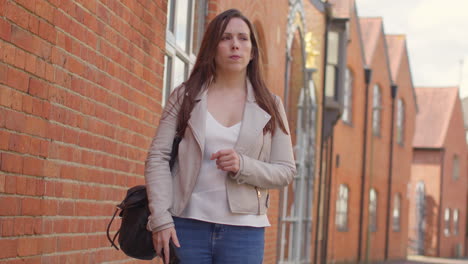 Stressed-And-Worried-Woman-Outdoors-With-Financial-Worries-About-Cost-Of-Living-Crisis-Debt-And-Paying-Bills-Looking-At-Mobile-Phone-On-City-Street-3