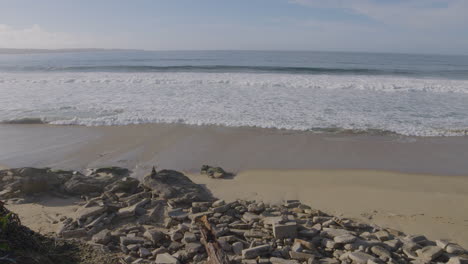 slow motion shot peaceful rolling waves onto a rocky shore on the west coast of california