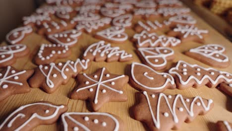 decorating gingerbread cookies for christmas, closeup macro shot making handmade festive new year sweets and cookies with white glaze icing