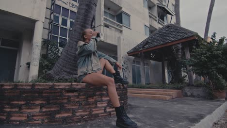 stylish woman sitting in abandoned building