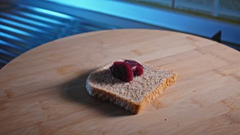 spreading low-calorie forest fruit jam on wholegrain bread toast