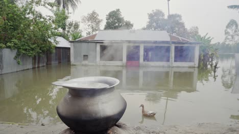 rice is boiling in front of a flooded house.